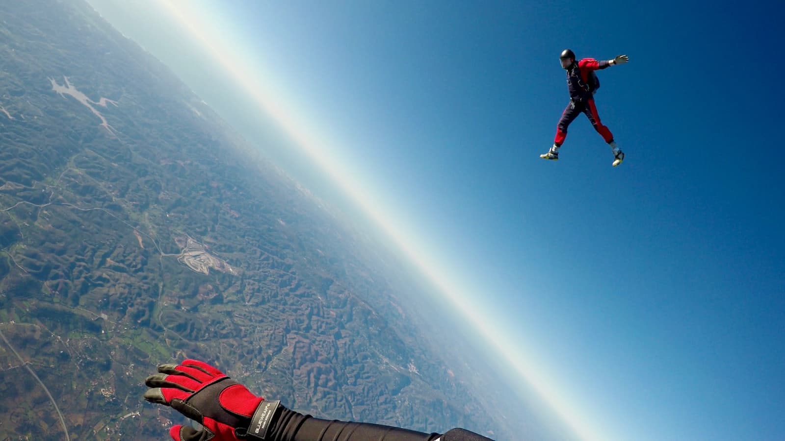 Skydiver in freefall above the coast
